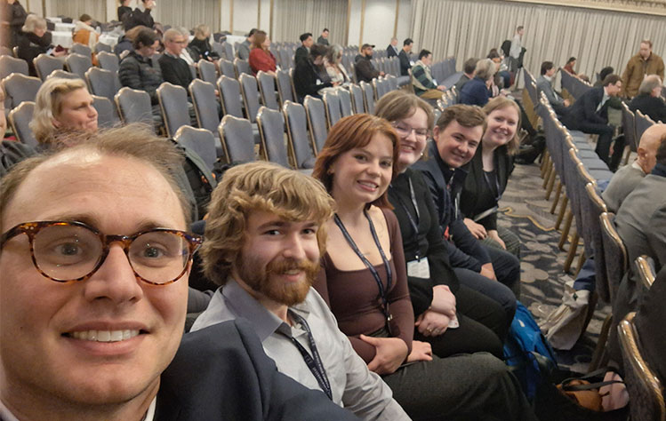 Dr. Belo and students sit in the audience waiting for a presentation to begin at the ISA conference.