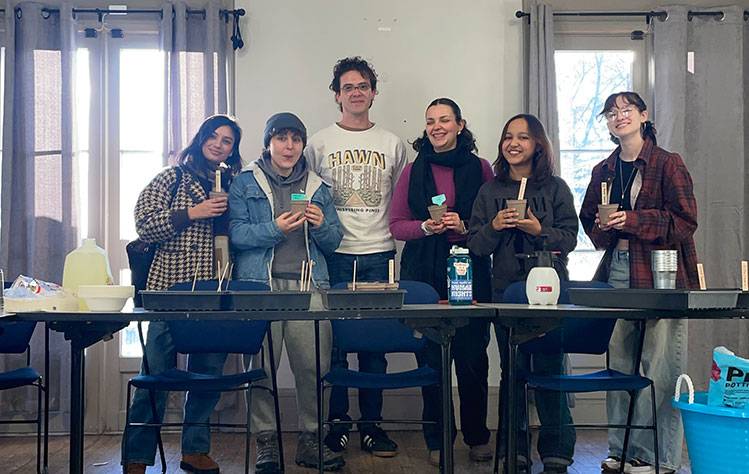 Students from the Webster Environmental Club pose with freshly sown seeds in the Pearson House.