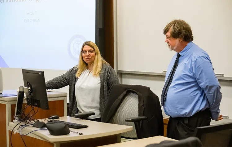 Gina Jensen and Tom Serfass stand at the front of the workshop presenting.