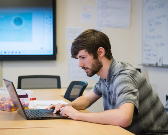 A webster student working on their laptop.
