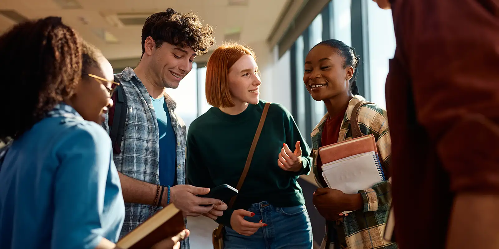 group of students meeting, talking, some holding books
