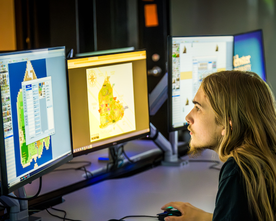 Student working at two computer screens