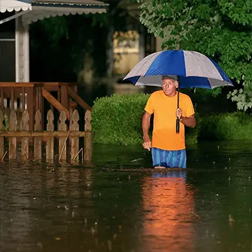 Robert Halbrook wades through thigh-high flood waters on Hermitage Avenue in St. Louis on Tuesday, July 26, 2022. 
