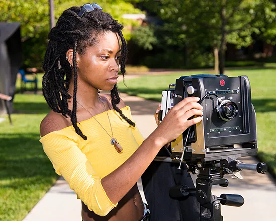 Woman uses a large format camera outside