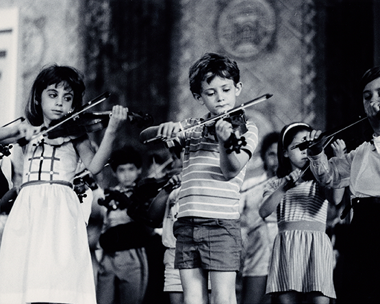 young children on stage playing violin