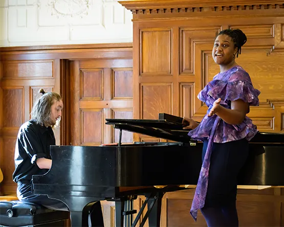 Student singing while accompanied on piano.