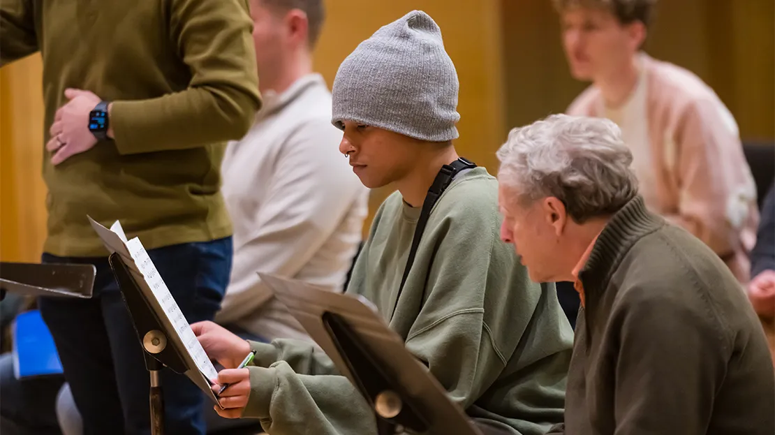Music student reviews their original composition with a professor