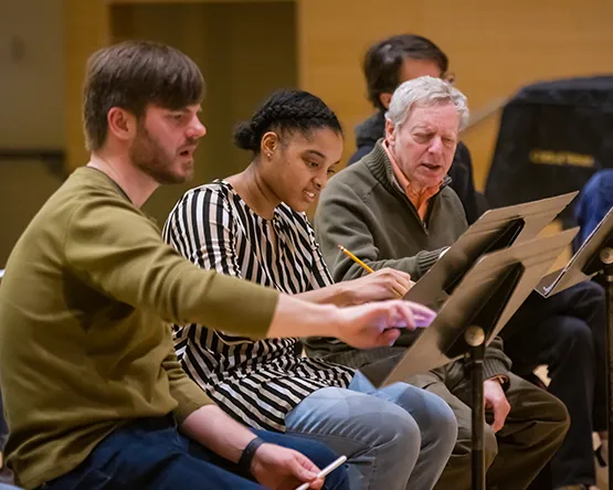 A music student receives feedback from professors on their original composition.
