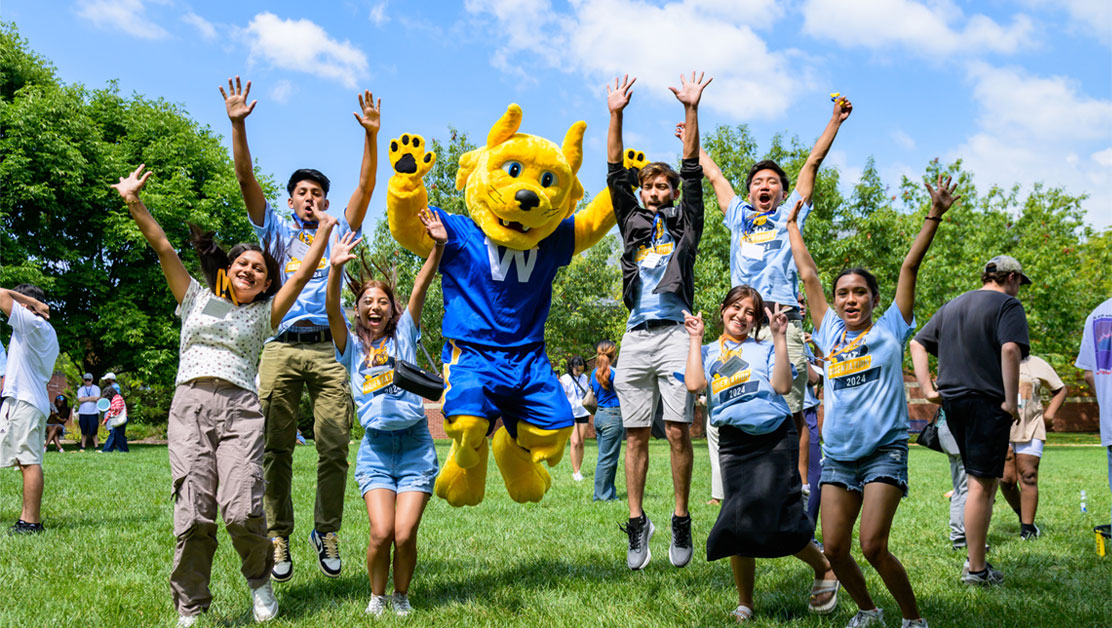 A group of students taking a group photo with the Gorlok mascot.