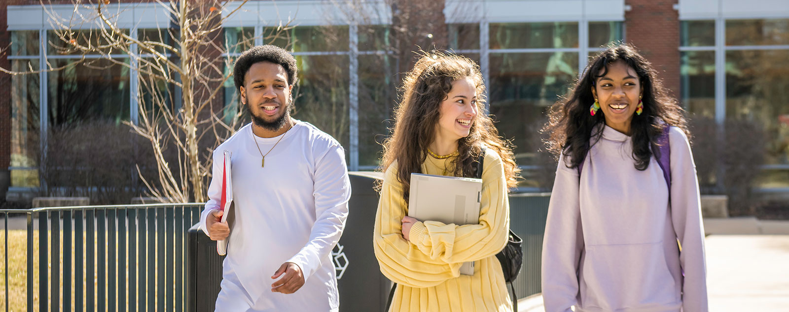 students walking together on campus holding books