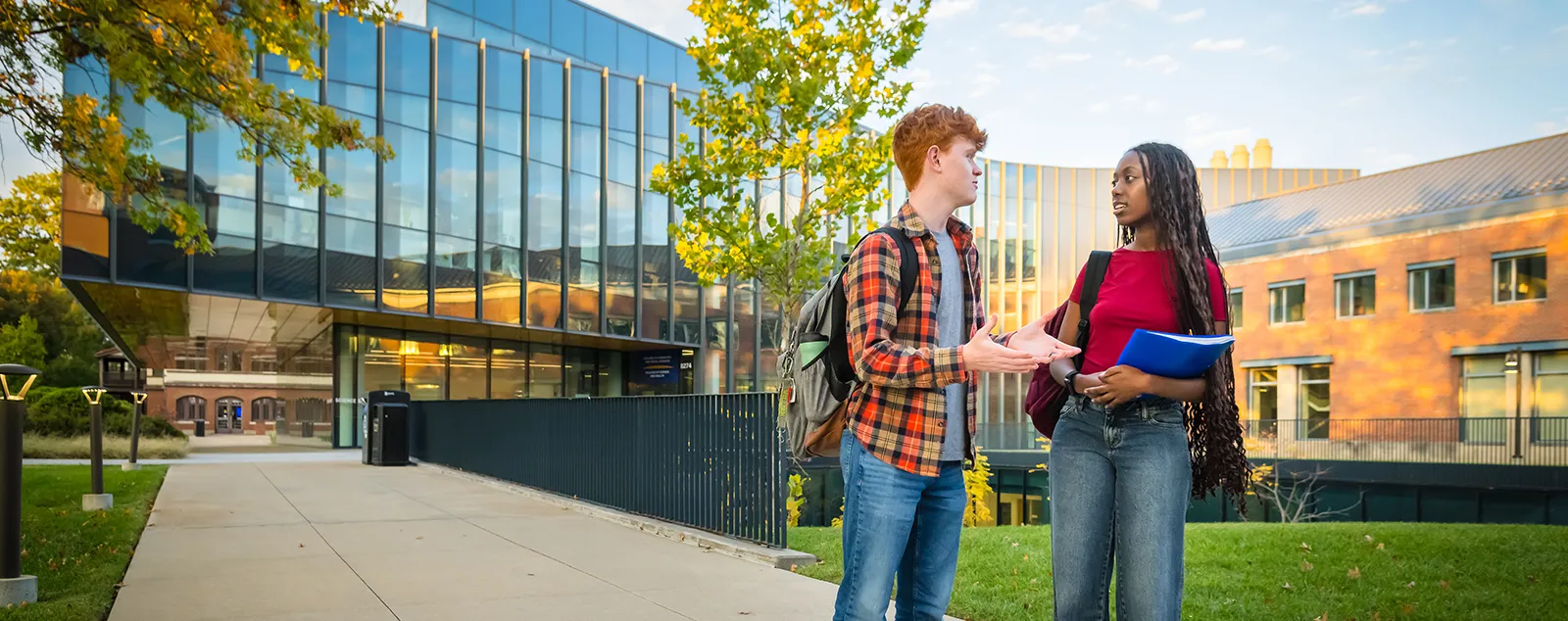 Webster students stand and talk outside of innovative Browning Hall.