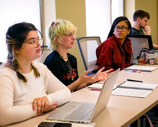 Students sit together at table and have discussion