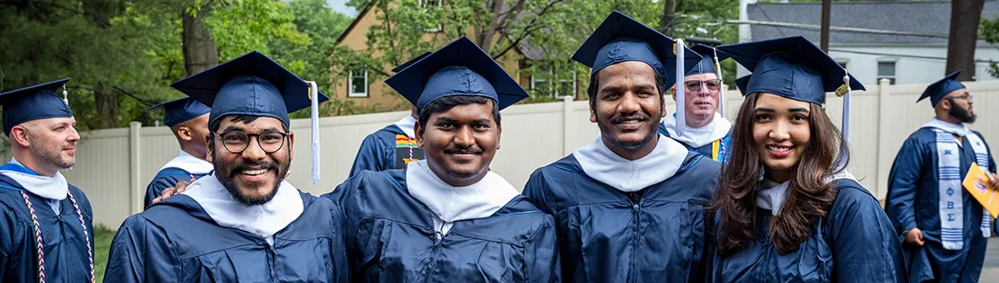 Several students standing together and smiling at Graduation.