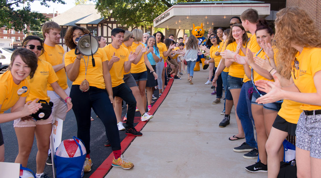 students wearing yellow shirts form a spirit tunnel