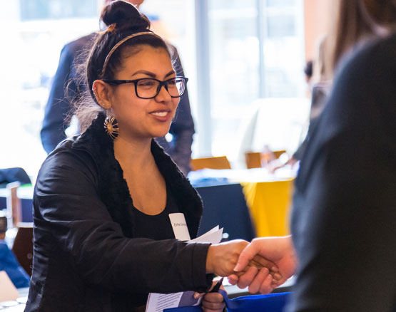 A student exchaning a handshake.