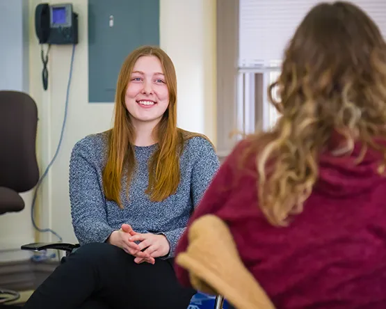 Student sits and talks with another student in class