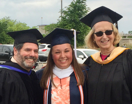Haley Walter in graduation robes with her professors
