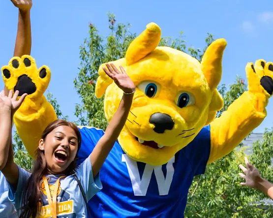 The Gorlok and a student with hands in the air, yelling, laughing