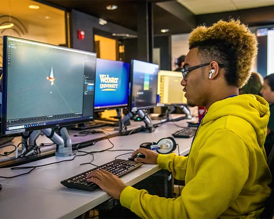 Student at a computer with a long line of computers to the right. 