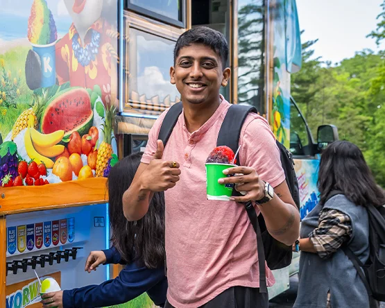 Student smiling and eating a snowcone.